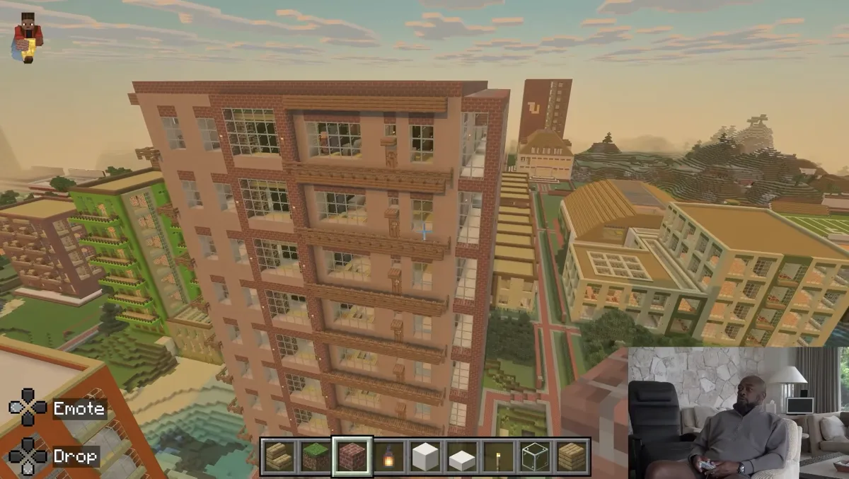 A tall brick apartment tower in Mike Tomlin's Minecraft city at sunset, with terraced buildings around it